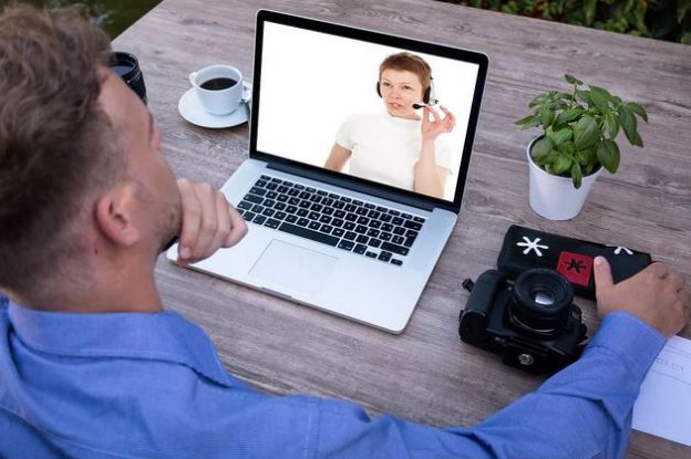 Man watching online briefing on laptop